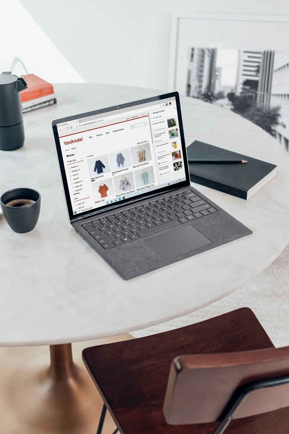 Portátil mostrando sitio web de comercio electrónico sobre mesa de mármol.